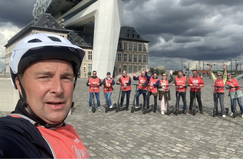 Stadsgids Danny voor het Havenhuis van Antwerpen met een groep mensen op een e-steptour
